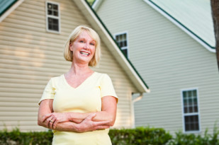 Mature woman standing outside home